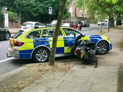 Police car resting against moped