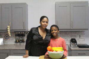 London vegan chef and CEO Omari McQueen and mom in kitchen.